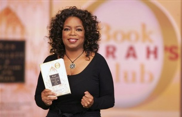 A photo provided by Harpo Productions, Inc., shows talk-show host Oprah Winfrey holding her latest book club selection, Ken Follett's "The Pillars of the Earth," during taping of the "The Oprah Winfrey Show" on Wednesday, Nov. 14, 2007, in Chicago. (AP Photo/Harpo Productions, Inc., George Burns)  ** NO SALES